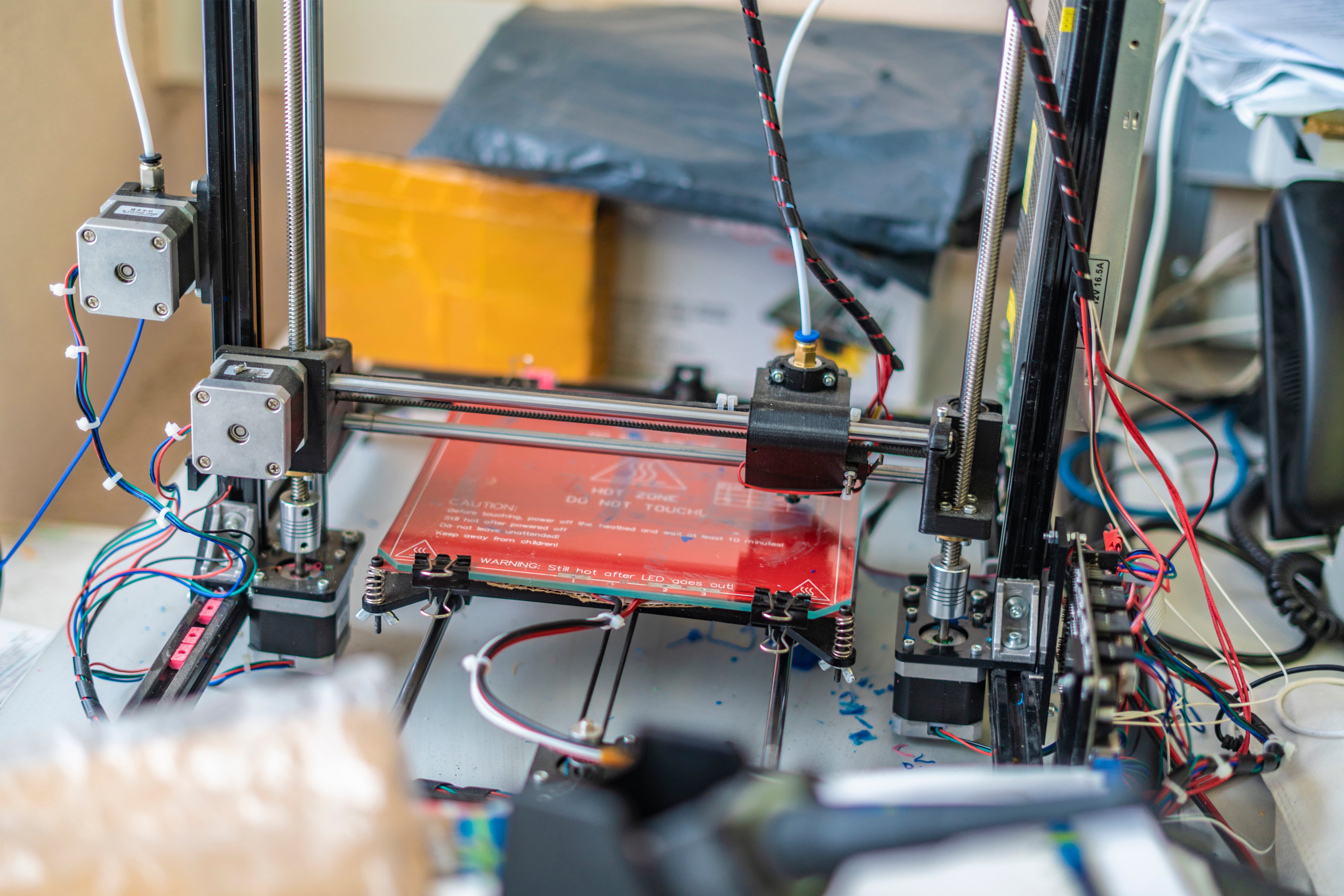 Load video: Close-up video of a 3D printer head moving smoothly on a gantry, building a partially completed 3D-printed boat. No sound.